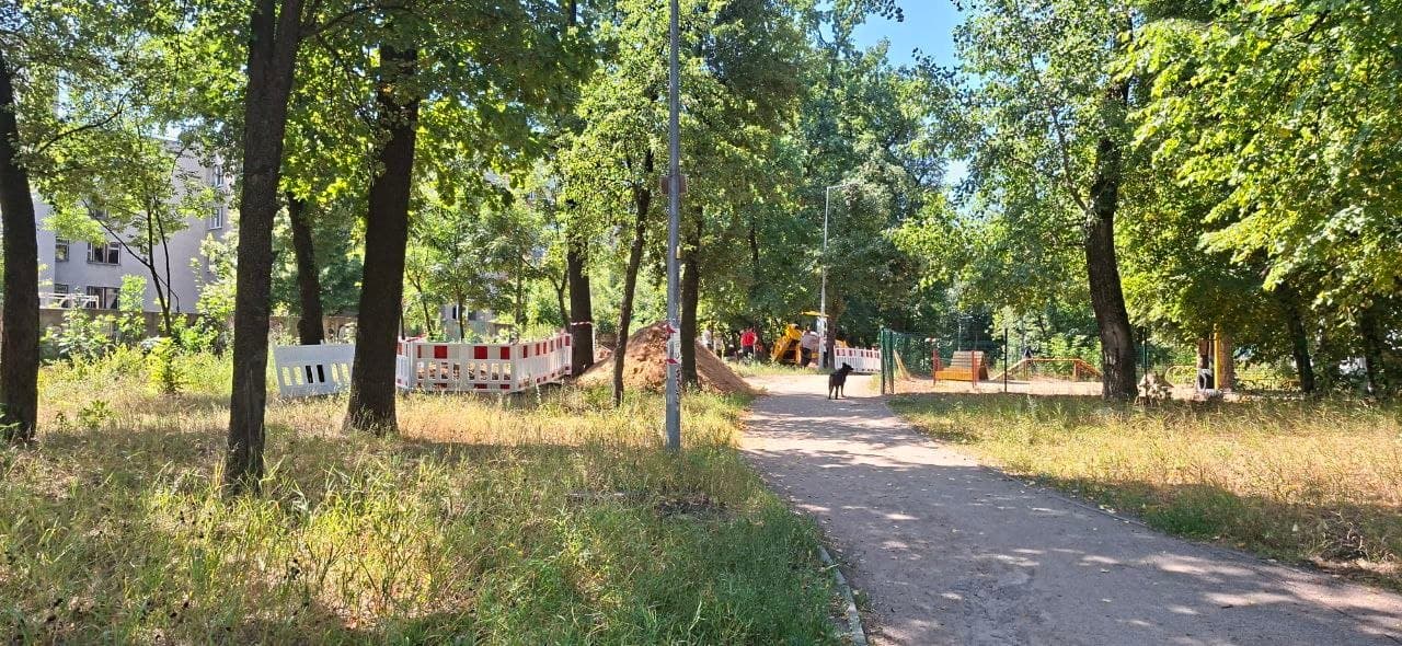 Огороджена ділянка робіт із важкою технікою біля паркової доріжки